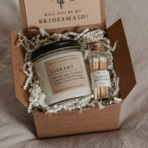 "Treat your favorite bookish friends with this dark academia bridesmaid proposal gift box! It contains everything they need to set the mood as they get lost in a good book. With a scented candle in a literary theme, a decorative glass bottle of white-tipped matches, and a custom-designed \"Will you be my bridesmaid\" card that doubles as a bookmark, this is the perfect way to make your proposal extra special! You can choose to invite any member of your bridal party to be a part of your wedding day - simply choose the title you need from the menu. Your proposal question will be printed on a card beneath beautiful, vintage style botanical artwork created by our resident artist, Sierra. If you need a title not listed here, just ask for it! We are happy to customize something for you, free of Bridesmaid Proposal With Candle, Bridesmaid Proposal Candles, Low Cost Bridesmaid Proposal, Edgy Bridesmaid Proposal, Bridesmaid Proposal Book Theme, Bridesmaid Candle Proposal, Simple Bridesmaid Proposal Box, Small Bridesmaid Proposal, Witchy Bridesmaid Proposal