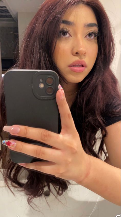 girl holding phone to take selfie in mirror with a deep dark cherry coke hair with a black phone case Dark Cherry Coke Hair Color Brunettes, Plum Hair On Brown Skin, Cherry Coke Hair Color Indian, Cherry Coke Hair On Brown Skin, Dark Cherry Coke Hair, Super Dark Red Hair, Berry Brown Hair Color, Deep Red Brown Hair Color, Dark Brownish Red Hair