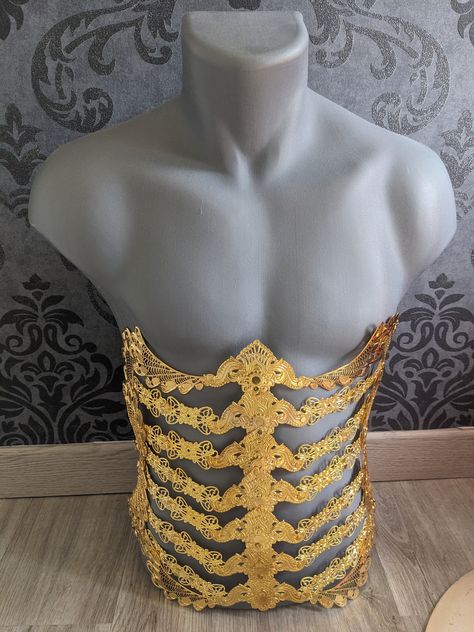 Body armor, made up of gold or silver colored metal pieces, depending on your choice. CONTENT: A corset belt under the chest entirely in metal. The line passing vertically reminiscent of a spinal column effect. To wear in one direction to emphasize the underside of the chest or in the other according to your desires. Gold or silver color, choose your version. To wear alone or on a garment, for a lingerie effect or an ultra original accessory. Finally the ideal accessory to complete all your outf Gold Armour Aesthetic, Ribcage Corset, Mens Corset, Corset Armor, Waist Armor, Fantasy Corset, Armor Corset, Male Corset, Metal Corset