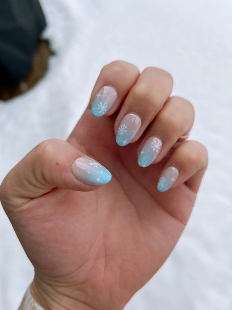 winter themed nails with blue to neutral ombre underneath a snowflake design Snowflake Nails Blue, Blue Ombre Nail Designs, Winter Nails With Snowflakes, Winter Snow Nails, Blue Snow Nails, Snowy Blue Nails, Light Blue French Tips With Snowflakes, Winter Themed Nails, Ombre With Snowflake Nails