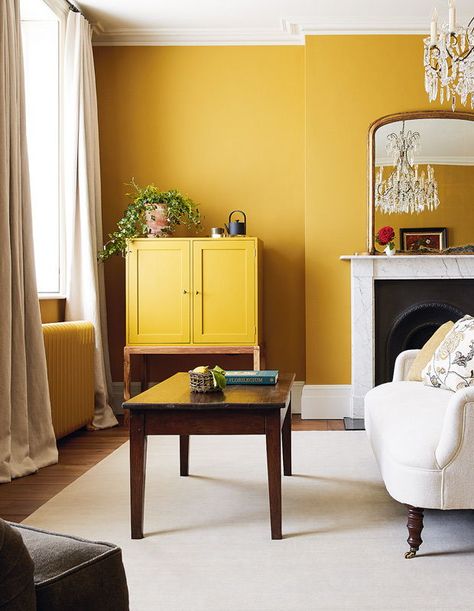 At Heckfield Place, the Ochre Room’s burnished yellow walls and ochre-painted cabinet and radiators create a cocooning effect. | Photographer: Courtesy of Heckfield Place Ochre Bedroom, Colour Drenching, Yellow Walls Living Room, Yellow Bedroom Walls, Dark Green Living Room, Mustard Yellow Walls, Yellow Dining Room, Mustard Walls, Wallpaper Tropical