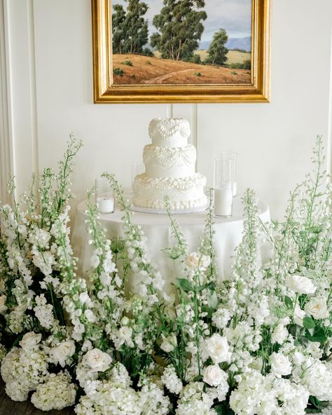 all white cake table surrounded by lush greenery and ivory florals Cake Table Florals, Cake Table Flowers, All White Cake, Cake Florals, Table Florals, Wedding Cake Table, Amazing Wedding Cakes, Simple Wedding Cake, Decor Flowers