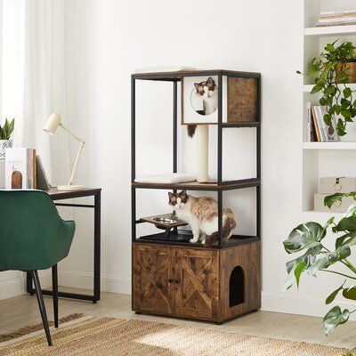 This cat condo comes with everything (except the cat). The black metal frame encloses a storage space with engineered wooden doors at the base to finally give you a place to hide the claw clippers your cat hates to see, while the raised bowl stand is just right for giving your cat the treats they deserve. Cut-out circles make traversing the three tiers an easy task for your feline, and whether they’re napping or playing, you’ll love to watch them in this cat tree. Color: Rustic Brown/Black | Arc Large Cat Tree, Niche Chat, Cat Litter Box Enclosure, Modern Cat Tree, Litter Box Furniture, Litter Box Enclosure, Cat Cave, Cat Condo, Modern Cat