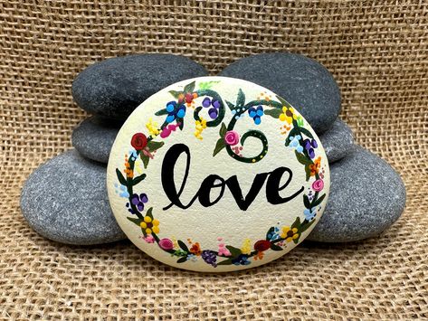 "🖐️ Hand Painted 📦 FREE Shipping From California 📐 Approximate Size: 2\" x 2\" Hand Painted rock with the word \"LOVE\" surrounded with colorful flower border. The back is painted white so you can add a personalized message if you would like. All our painted rocks are packaged in a colorful bag (colors vary), wrapped in bubble wrap and includes a hand written thank you note. We also include a FREE gift to all returning customers. Because Nature never creates identical rocks and all our rocks Wedding Rock Art Painted Stones, Floral Rock Painting Ideas, Painted Rock Flower Garden, Roses Painted On Rocks, Nature Themed Painted Rocks, Fondant Flower Tutorial, Rock Hand, Stone Art Painting, Colorful Bags