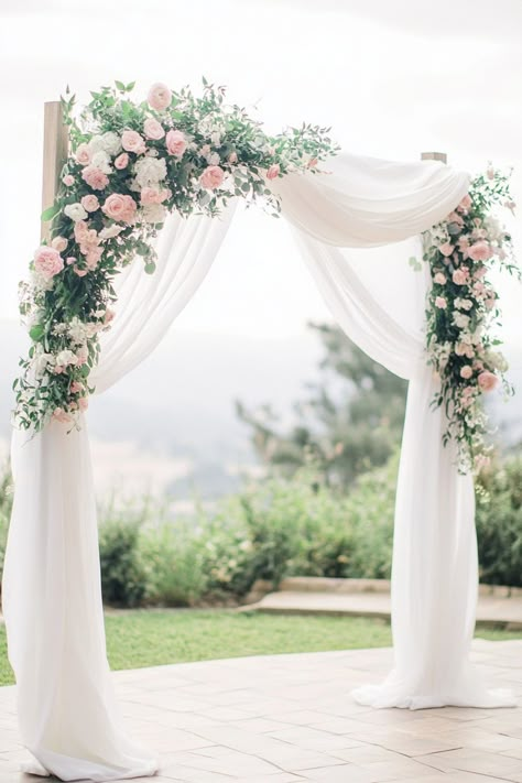 Floral wedding arch with white drapes and greenery, set outdoors. Simple Outdoor Wedding Ceremony Decor, Wood Arches Wedding, Simple Wedding Backdrop Indoor, Wedding Arch Decor Ideas, Arch Decor Ideas, Wedding Arch Decoration Ideas, Arch Decoration Ideas, Wedding Arch Decorations, Wedding Arch Decor