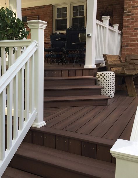 This warm, classic brown is an ideal accent to this beautiful, brick home. Click to see all of our timeless browns, like Symmetry Burnt Umber (shown here), or take a look through our entire versatile color offering. Trex Deck Brick House, Brick House Deck Colors, Brick House Back Porch, Deck Color Ideas For Red Brick House, Decks On Brick Houses, Back Deck Paint Colors, Back Deck Color Ideas, Deck Colors Ideas Paint Brick House, Painted Decks Colors Ideas Brown