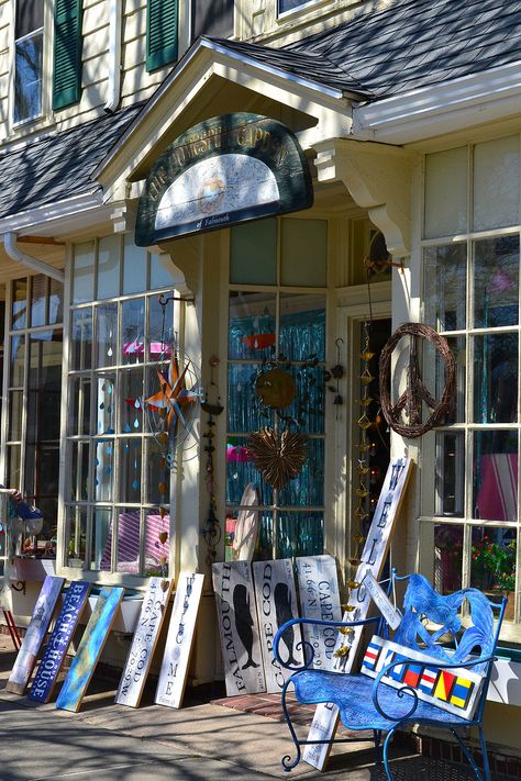 Storefront of Homespun Garden on Main St. in downtown Falmouth, Massachusetts.  Wooden signs, a blue outdoor bench, metal sculpture and peace symbol decor are propped up in front of the shop outside the door. Falmouth Cape Cod, Falmouth Massachusetts, Cape Cod Travel, Nantucket Massachusetts, Buzzards Bay, Holly Tree, Cape Cod Massachusetts, Early Autumn, Falmouth