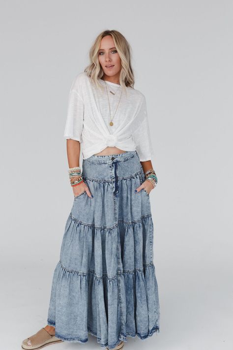 This stunning Gemma Tiered Denim Maxi Skirt combines a tiered design with mineral washed fabric, creating a unique and effortlessly boho-chic look that is sure to turn heads wherever you go! You’ll step out with confidence, radiating bohemian charm with every step you take in this skirt because it features: Mineral washed Tencel fabric for a stylish and vintage-inspired look Relaxed and loose, tiered silhouette at a maxi length Classic button-fly front closure with an elastic gathered back piece Denim Skirt Boho Outfit, Flowy Denim Skirt Outfit, Flowy Outfits, Boho Closet, Summer Thrift, White Jumpsuit Dress, Teacher Clothes, Denim Skirt Outfits, Boho Outfit