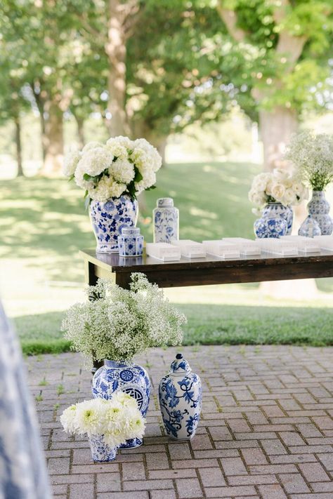 Close-up of the stunning white floral arrangements in blue and white ginger jars at Claire and Alec's wedding. These elegant details added a timeless touch to their reception decor. Blue And White Spring Wedding, Blue And White Flowers Wedding, Ginger Jar Floral Arrangements, Red White And Blue Wedding, Blue And White Ginger Jars, Blue And White Vases, Finger Lakes Wedding, White Floral Arrangements, Blue And White Wedding