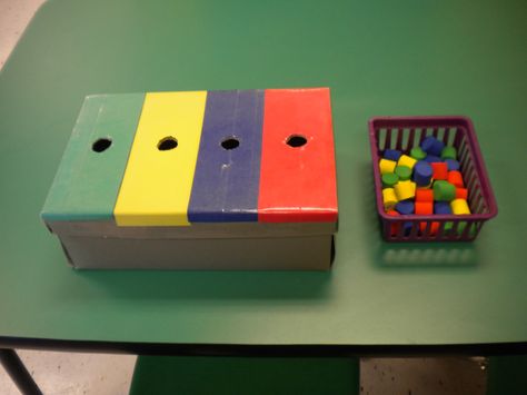 Sort by colour.  Just get an old shoe box and make the holes slightly larger than the coloured objects.  Cover the box with colored paper and clear tape. I inserted dividers inside the box so I could check work upon completion. I bought the cylinders at the dollar spot in Target. Teacch Activities, Sort By Color, Preschool Colors, Task Boxes, Teaching Colors, Clear Tape, Work Boxes, Independent Work, Sorting Activities