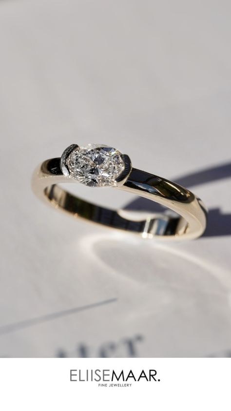 A Yellow Gold engagement ring with an oval diamond set on its side with a thick band East West Marquise Ring Half Bezel, Oval East To West Engagement Ring, East West Oval Diamond Ring, Oval East West Ring, East West Half Bezel, Half Bezel Setting, Half Bezel, Oval Engagement Ring, Oval Engagement