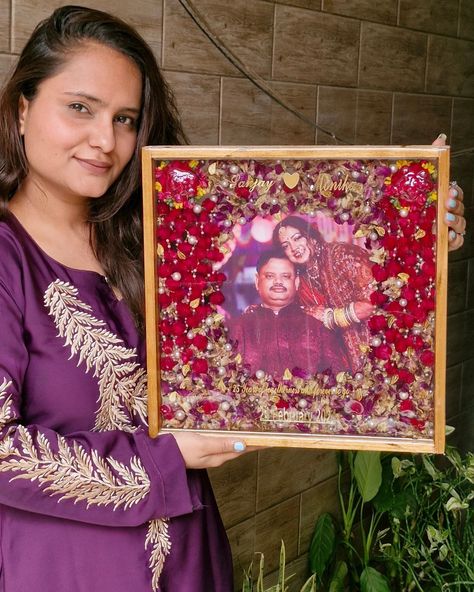 I am delighted to share this beautiful teakwood frame preserved with a vibrant pair of kaleeras and a varmala. It was created as a 25th-anniversary gift from a daughter to her parents, and I am thrilled to report that they were overjoyed with the result.✨️🧿 The feedback from the client was incredibly positive, and it brought me immense joy to know that my creation was so well-received. Both the daughter and her parents expressed their love for the frame, and I am proud to have been a part of... Flowers Varmala, Wedding Preservation, 25th Anniversary Gift, Anniversary Gifts For Parents, A Daughter, The Client, How To Preserve Flowers, Parent Gifts, 25th Anniversary