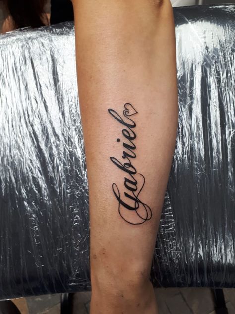 Gabriel Tattoo Design, Chest Name Tattoo Female, Partner Name Tattoos, Forearm Name Tattoos For Women, Gabriel Tattoo, Small Name Tattoos, Small Name Tattoo, Forearm Name Tattoos, Tattoo Text