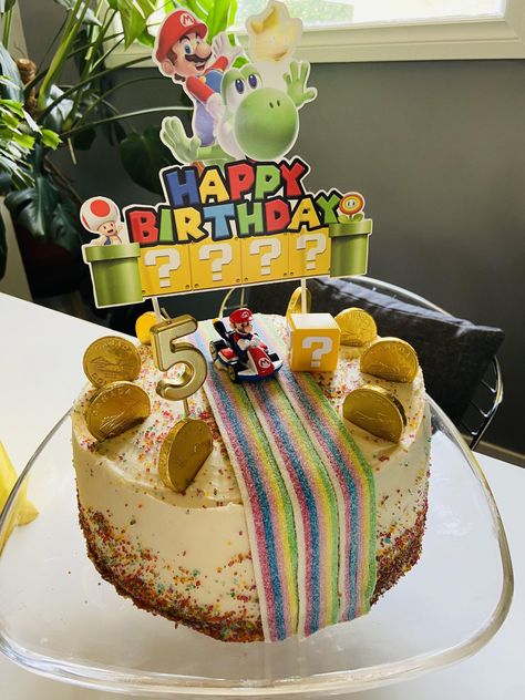 Confetti cake with vanilla buttercream. Sour belts for the road, rainbow sugar sprinkles, chocolate coins and a Mario hot wheels! by 10eel Mario Birthday Birthday Cake, Mario Kart Cake Ideas, Mario Kart Rainbow Road Diy, Mario Birthday Cake Diy, Super Mario Birthday Party Cake, Easy Super Mario Cake, Super Mario Kart Cake, Mario Birthday Cakes, Rainbow Road Cake