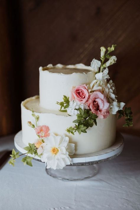 This wedding cake is decorated in pink spring florals like garden roses, dahlias and ivy. Wedding Cake With Flowers On Top, Small Spring Wedding Cake, Spring Garden Wedding Cake, Bridal Shower Cake Flowers, Love Is In Bloom Bridal Shower Cake, Bridal Shower Cake Floral, Pastel Floral Wedding Cake, Love Is In Bloom Cake, Garden Party Wedding Cake