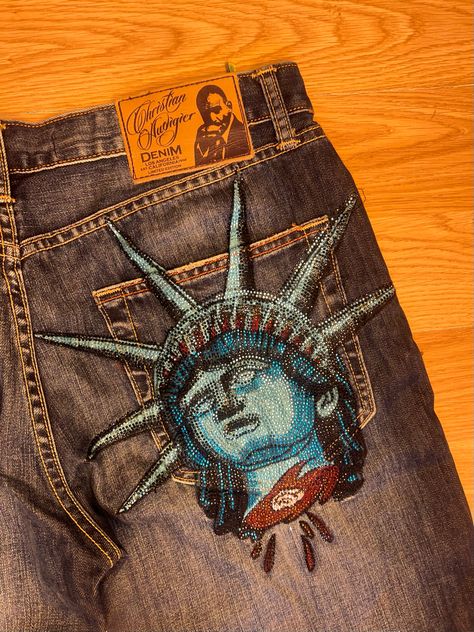 Christian Audigier Jeans, Jean Painting Ideas, Ed Hardy Jeans, Apparel Design Inspiration, Diy Clothes Design, Custom Jeans, Custom Denim, Christian Audigier, Sleeves Clothing