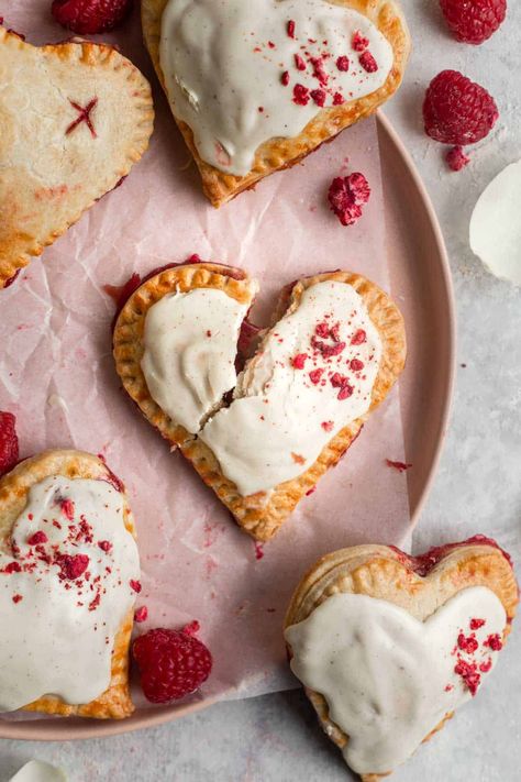 These Heart Shaped Raspberry Hand Pies make the perfect sweet treat for Valentine’s Day. Made with a flakey sweet short crust pastry and filled with fresh raspberries, raspberry jam and white chocolate, these mini pies are a delicious homemade dessert. By Emma Duckworth Bakes Raspberry Hand Pies, Chocolate Pop Tarts, Comidas Aesthetic, Lemon Meringue Tart, Romantic Desserts, Chocolate Pops, Hand Pie, Freeze Dried Raspberries, Homemade Dessert