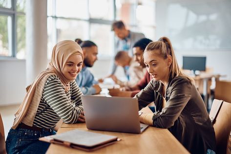 Happy Muslim student and her college friend cooperating while  using laptop during a class at college classroom. University Advertising, Campus Photography, Nursing Pictures, Stock Photos People, School Photoshoot, College Classroom, Study Spaces, Photography Moodboard, Student Photo