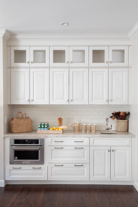 Traditional, all-white butler's pantry with clean white tile backsplash, silver finishings, and a marvelous granite countertop. A clean and simple storage design brought to life with some coastal new england touches, creating the perfect place in your home to display these gorgeous summer pieces. #coastal#newenglandcoastal#newnenglandsummer#storage#whitekitchen#rattan#Instagram#pinterest#aesthetic#homedecore#design#Hillsboroughg#architecture#photography#art Photo By Vivian Johnson Photography Coastal New England, White Tile Backsplash, Summer Pieces, Coastal House, Granite Countertop, Designer Interior, Butler's Pantry, Pinterest Aesthetic, Storage Design