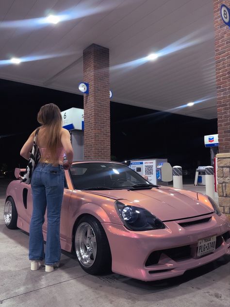 A girl posed next to a pink M-R-2 Spyder. The type of pink can be described as a warm summer evening. Toyota Mr2 Wallpaper, Pink Toyota, Suki Pink Car Aesthetic, Mr2 Toyota Wallpaper, Toyota Spyder Mr2, Mr2 Toyota, 2003 Toyota Mr2 Spyder, Toyota Mr2 Sw20, Raw Aesthetic