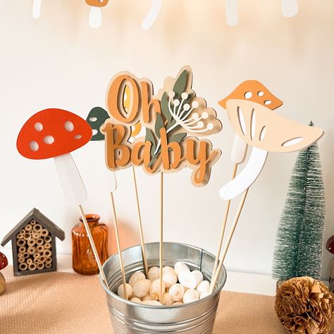 Mushroom Centerpieces for table is an awesome decorations for your Baby Shower Party! Welcome your Little One in style with this unique Oh Baby toppers. Its eye-catching winter design is perfect forLittle Fungi is on Their Way, Mushroom, Cottagecore, Toadstool, Enchanted Forest and Neutral Baby Shower party perfectly. High quality and great design - our priorities. So those party decorations are exclusively made for our dear customers. BANNER FEATURES * Custom colors and text option available * Colors: Red, Green, Orange, Tan, White * This stylishly Mushroom Centerpieces is embellished with a cute mushrooms, green leaves and Oh Baby text, giving it a unique and special look. Perfect for baby girl shower! * Ready to use * 100% handmade ⇒ If you want to customize a Centerpieces, please feel Mushroom Centerpiece Party Ideas, Mushroom Forest Theme Party, Enchanted Forest Theme Baby Shower Ideas, Mushroom Baby Shower Theme, Baby Shower Mushroom Theme, Cottagecore Baby Shower Ideas, Mushroom Themed Baby Shower Ideas, Forest Friends Baby Shower Ideas, Forest Themed Baby Shower Ideas