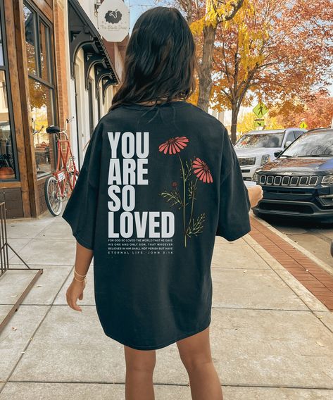 Our new You Are So Loved shirt was designed as a way for believers to share the good news of Jesus wherever they go.  Printed on the back of high quality Comfort Color shirts in a trendy streetwear style, this shirt will become a favorite in your closet.  Whether you are sharing your faith or gifting it to someone special, this shirt is the perfect reminder of God's gift to us in Jesus.   Back print only.  Check out this listing if you want a front and back print! https://www.etsy.com/listing/1544650907 Please check the size chart and size up a couple sizes for an oversized look. *The larger the shirt, the larger the graphic.  Our printer sizes the graphics proportionate to the size of the shirt.   **Please understand that due to the handmade nature of this item, the design placement, colo