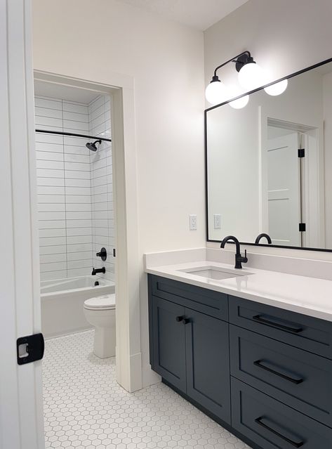 Black Hexagon Tile Bathroom White Vanity, White Bathroom With Dark Cabinets, Black And White Bathroom With Colored Vanity, Black And White Bathroom With Wood Floor, Navy Kids Bathroom, Black Hardware In Bathroom, Charcoal Vanity Bathroom Ideas, Black Appliance Bathroom, Modern Bathroom Hexagon Tile