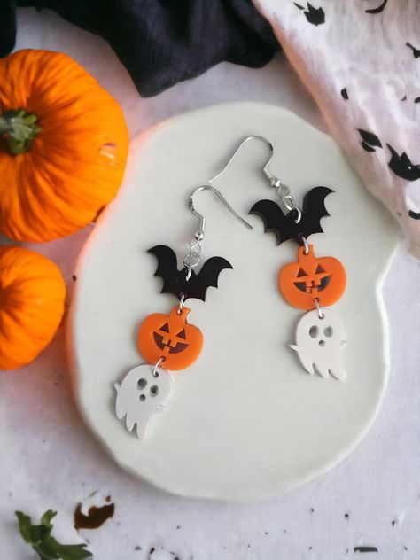 Get ready to spook up your Halloween look with these adorable pumpkin bat ghost trio earrings! Made with high-quality acrylic, these earrings are perfect for adding a touch of festive fun to any outfit. The cute and quirky design features a trio of Halloween icons, including a grinning pumpkin, a spooky bat, and a friendly ghost. Whether you're dressing up for a Halloween party or just want to add some seasonal flair to your everyday look, these earrings are a must-have accessory! Halloween Trio, Clay Kawaii, 3d Earrings, Alt Clothing, Polymer Clay Kawaii, Bat Earrings, Jewelry Halloween, 3d Jewelry, Halloween Beads