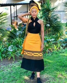 Xhosa Beauty In Orange and black Umbhaco Skirt, Doek and Bag With Black Top and sneakers Umbaco Xhosa, Xhosa Skirt, Xhosa Traditional Attire, Xhosa Attire, South African Traditional Dresses, Traditional Skirts, African Traditional Wear, Traditional African Clothing, Fashion Traditional