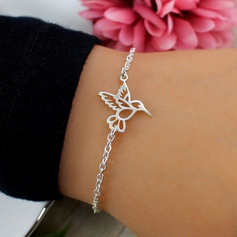 "Hummingbird Bracelet.  This elegant and simple Hummingbird Bracelet features a Hummingbird Charm on a sterling silver cable chain finished with a lobster clasp closure.  Bracelet is solid sterling silver, fully adjustable and comes with the option to add a complimentary, custom printed gift tag. Hummingbirds float free of time. They can open our eyes to the wonder of the world and inspire us to savor each moment as it passes, embrace all that life has to offer and to celebrate the joy of everyd Simple Hummingbird, Hummingbird Ring Jewelry, Hummingbird Bracelet, Hummingbird Earring, To The Wonder, Bird Bracelet, Silver Bird-shaped Jewelry For Gift, Hummingbird Jewelry, Wonder Of The World