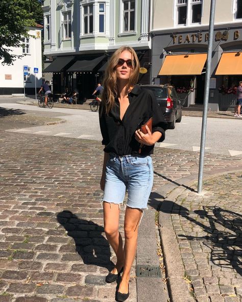 How to Wear Denim Bermuda Shorts — Cecilie Moosgaard Nielsen spring or summer outfit idea with a black button-down shirt, wallet clutch bag, and black ballet flats Denim Bermuda Shorts Outfit, Cecilie Moosgaard, Bermuda Shorts Outfit, Long Jean Shorts, Denim Shorts Outfit, Looks Jeans, Denim Inspiration, Stylish Summer Outfits, Spring Shorts