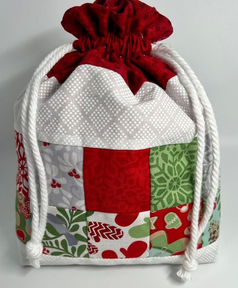 "https://love2bestitchin.etsy.com These gift bags will add an extra special touch to any gift this holiday season. Pieced 2 1/2\" squares reminiscent of grandma's quilt, fully lined with no open seams. It is a great way to add value to your gift without the waste of paper, plus it's reusable so the recipient can gift it to someone else next year...the gift that keeps on giving. Christmas Fabric Gift Bag, Holiday Drawstring Reusable Gift Wrap, Eco Friendly Wrapping Candle, Bear and other props ar Fabric Drawstring Gift Bags, Santa Bags Diy, Sew Christmas Gift Bags, Sewn Gift Bags, Christmas Fabric Gift Bags, Fabric Gift Bag Pattern, Fabric Gift Bags Diy Free Pattern, Christmas Gift Bags To Sew, Fabric Christmas Bags