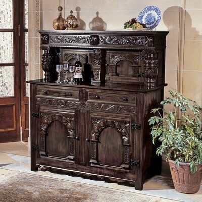 A 19th-century antique replica in the Jacobean style, our signature solid mahogany buffet is embellished with deep hand carvings including a caricature of a nobleman, melon bulb turnings and floral arches. A true work of fine craftsmanship echoing past centuries, our Toscano exclusive, taking over two weeks to complete, fills the timeless need for storage with its two upper cupboards, deep drawers, and shelved bottom cabinets, all featuring exposed period iron hardware. Ships in two pieces. Brown Cupboards, Floral Arches, Jacobean Style, Medieval Gothic, Gothic Furniture, Rustic Traditional, Solid Wood Sideboard, A&b Home, Iron Hardware