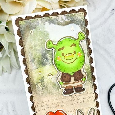 Davina on Instagram: "“That’ll do Donkey… that’ll do” 💚💚 Today I’m sharing a story book slimline featuring everyone’s favorite ogre. I made this Shrek inspired card using new stamps from @sandraspitaleri The Sassy Club called Green Ogre. There is a Puss in Boots character too but I couldn’t fit him on this scene. Originally I was trying to color these with my Zig markers, but I got frustrated and re stamped them for copics 😂 I love how cute these images are and can’t wait to see if there wil Shrek Birthday Cards, Donkey Shrek Drawing, Sassy Club Cards, Shrek Donkey And Dragon, The Sassy Club Stamps, Club Card, Shrek, To Color, Card Maker