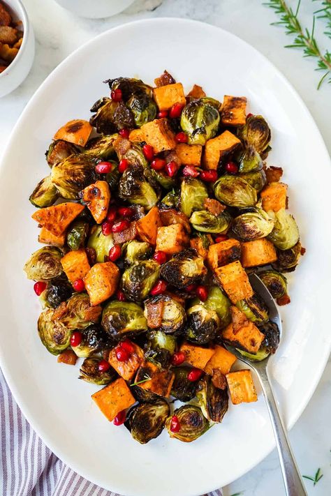 These Roasted Brussels Sprouts with Sweet Potatoes are going to be your new favorite for your holiday table! Perfectly roasted brussels sprouts and tender sweet potatoes are drizzled with a sinful bacon and maple glaze, then topped with crispy bacon and pomegranate seeds for a little crunch. Even brussels spouts haters won't be able to resist this easy holiday side dish! Brussels Spouts, Brussels Sprouts And Sweet Potatoes, Cracked Green Beans, Sprouting Sweet Potatoes, Easy Holiday Side Dishes, Holiday Pie, Canned Cranberry Sauce, Au Gratin Recipes, Green Beans With Bacon