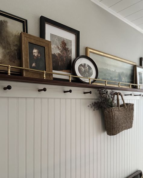 The DIY brass rail gallery wall deserves some still photos😍 I wish I could take credit for this idea, but Jeff was actually the one who brought it up! I’m so glad he did because it brings so much warmth and character to the space! And I have another place to display art 😂 Comment SHOP below to receive a DM with the link to shop this post on my LTK ⬇ https://liketk.it/4ShTY #mixerofstyles #interiordesign #hometakestime #transitionaldesign #mydomaine #wearevivir #mycrumbshome #bhghome #bhgst... Picture Ledge Coat Rack, Tall Picture Frame Ideas, Wainscoting Ideas With Shelf, Picture Frame Ledge Ideas, Entryway Picture Ledge, Craftsman Picture Rail, Art Rail Display, Large Empty Frame Ideas, Gallery Wall Rail