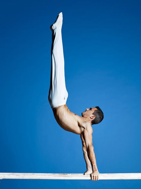 Hamilton Sabot wearing white ling trousers, doing gymnastics on white parallel bars with a ocean blue background Gymnast Reference, Gymnastics Poses For Pictures, Gymnastics Aesthetic, Ocean Blue Background, Athlete Photography, Male Gymnast, Gymnastics Poses, Gymnastics Photos, Gymnastics Photography