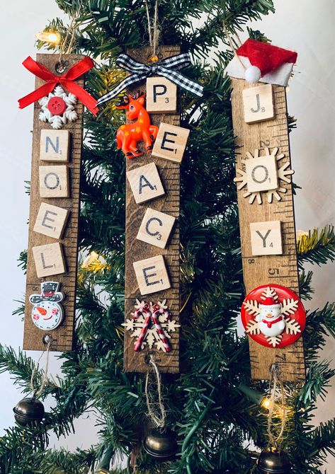 Handcrafted Scrabble Christmas Ornaments on stained yardsticks.   These unique ornaments will feature a "Festive" word using wooden Scrabble tiles and a jingle bell on bottom attached by twine.   Each ornament offers an additional handmade touch with a hand-tied bow, strategically placed tiles, and glued/layered embellishment on a stained yardstick.   Some embellishments will differ regarding availability.    These cuties are ready to hang on your tree using twine hanger (attached) or given as a gift to that special someone! Each ornament will be wrapped with care using bubble wrap and placed in a bubble envelope or appropriate sized box.  Tracking will be provided and all orders SHIP FREE! Scrabble Christmas Tree, Scrabble Tile Christmas Ornaments, Scrabble Tile Crafts Christmas Gifts, Scrabble Ornaments Diy, Scrabble Christmas Ornaments, Scrabble Christmas, Scrabble Ornaments, Scrabble Tile Crafts, Scrabble Crafts