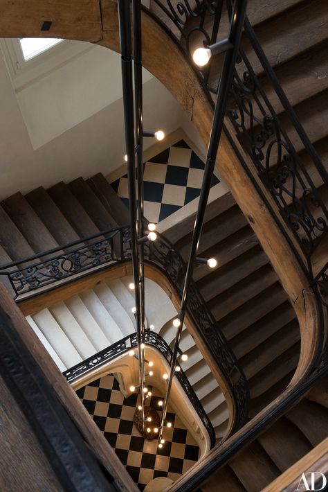 Yovanovitch designed a 45-foot-long light fixture, composed of three black metal rods, for the main staircase of his Paris office. Parisian Office, Victorian Staircase, White Staircase, Pierre Yovanovitch, Parisian Architecture, French Apartment, Wood Staircase, Staircase Design, Architectural Digest