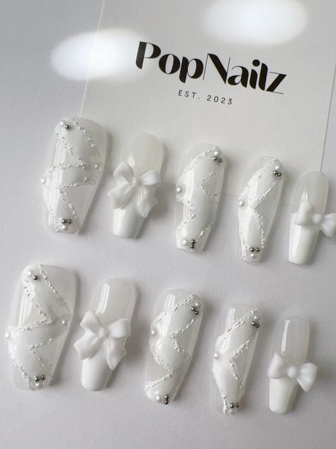 Welcome to PopNailz, your premier destination for high-quality handmade press-on nails that blend elegance and convenience. Our Elegant White Lace and Bow Press-On Nails are meticulously crafted to offer you a salon-quality manicure from the comfort of your home. Product Features: Handmade Excellence: Each nail is carefully hand-painted and adorned with delicate lace patterns and charming bow accents, ensuring a unique, high-quality product. Reusable & Durable: Designed for multiple uses, our pr Nail Art Designs White Nails, Cute White Long Nails, Cute Nail Designs White, Nail Salon Pictures, White Korean Nails, White Elegant Nails, White Nails With Charms, Nail Art Designs White, Korean Press On Nails