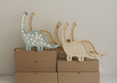 Our high-quality children's night light is handmade from 100% natural pinewood, making it as strong and durable as it is beautiful. The Little Lights Dinosaur Lamp is a gentle giant who adds an aura of ancient wonder to your nursery decor. Give your little paleontologist the gift of a prehistoric pal by ordering one today! Size (in inches): 23.5x13x3 Solid Pinewood LED Lights / Warm White 2,2W Input: AC 100-240 Output:DC24V Switch on the cord Dimmer Care & Cleaning How To Clean Light Fixture Dino Lamp, Dinosaur Lamp, Kids Table Lamp, Childrens Night Light, Glider Rocking Chair, Dinosaur Posters, Brass Light Fixture, Deco Originale, Dinosaur Wall