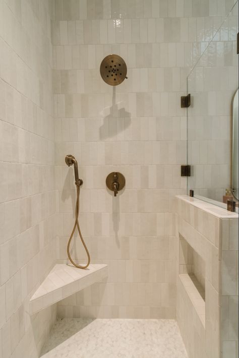 Kept it warm and soft in this Tween’s bath using a palette of creams and brass paired with a reflective tile 🤍, cabinet hardware, bathroom accessories, towel bar, soap dispenser, bathroom tray, bathroom faucet, bathroom plumbing, bathroom shower, bathroom tile, wall mirror, bathroom mirrorr Follow my shop @Thedendesigngroup on the @shop.LTK app to shop this post and get my exclusive app-only content! #liketkit #LTKstyletip #LTKhome #LTKsalealert @shop.ltk https://liketk.it/4thdi Neutral Master Shower Tile, Bathroom Shower Tile Ideas Cream, Shower Niche In Pony Wall, Shower Tile Neutral, Organic Shower Design, Neutral Shower Tile Ideas, Shower Renovation Ideas, Neutral Shower Tile, Vertical Tile Shower Ideas