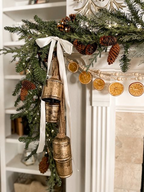 Christmas Fireplace Garland Farmhouse, Styling A Christmas Mantle, Fireplace Garland And Bells, Taxidermy Christmas Decor, Christmas Decor Ideas For Window Display, Scandi Christmas Garland, Christmas Gold Bells, Gold Christmas Bells Decorations, Garland With Gold Bells