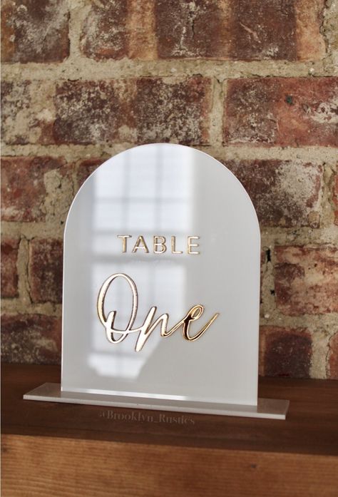 "Acrylic Table Numbers with stand, Arch Acrylic Table Numbers DISCLAIMER: Please use a dry, clean cloth to wipe down your sign/s. This item includes 1: - Arch 1/8 acrylic sign with 1/8 in acrylic letters. - 1/8 in thick stand/base (matching color base)  DIMENSIONS: - 5.5 in wide x 7 in tall - 6.5\" wide x 1.75\" base MATERIALS: - Acrylic If you would like additional signs for menu, gifts and cards, bar menu, drink stirrers, acrylic place cards etc we would be happy to create these for you. Price Table Number Acrylic, Acrylic Table Signs, Arched Table, Menu Drink, Acrylic Place Cards, Arch Table, Wedding Reception Hall, Menu Table, Acrylic Table Numbers