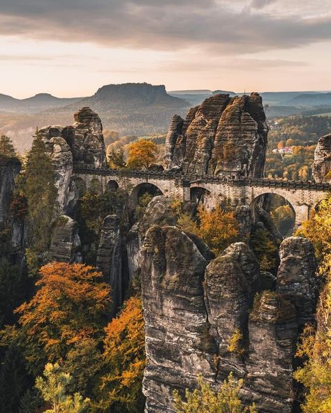 Bastei Bridge is one of the most famous landmarks you'll see in Saxon Switzerland, Germany. From here, you can feast your eyes on the River Elbe, Lilienstein Mountain, the Koenigstein Fortress, and Saxon Switzerland National Park. Saxon Switzerland National Park, Grimentz Switzerland, Saxon Switzerland, Neuswanstein Castle, Schwerin Castle Germany, Beautiful Germany, Places Worth Visiting, Instagram Autumn, Famous Landmarks