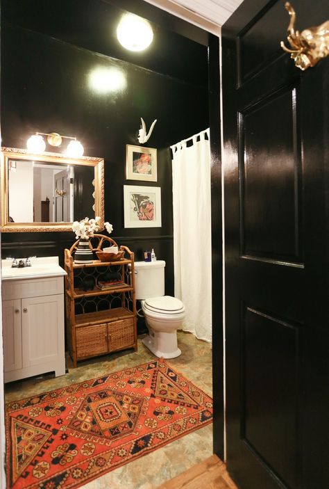 Bold dark bathrooms can totally work if done right and planned well. Black walls, when met with white linens and fixtures and a statement vintage rug make this space unforgettable and a color scheme that you never knew you wanted! House Tour: Southern, Bohemian Charm in Nashville | Apartment Therapy Brighten Bathroom, Windowless Bathroom, Moore House, Dark Bathrooms, Eclectic Bathroom, Frameless Shower Doors, Dark Walls, Vintage Bathrooms, Black Bathroom