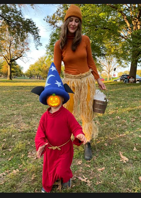 Child in red robe and blue wizard hat with Mickey ears next to a woman dressed as a broom Baby Wizard Costume, Sorcerer Mickey Nursery, Sorcerer Mickey Costume, Mickey Sorcerer Hat, Sorcerer Apprentice Mickey, Broom Costume, Mickey Costume, Sorcerer Mickey, Family Costumes