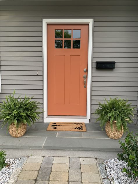 Orange Entry Door, Terracotta Front Door White House, Burnt Orange Exterior Door, Terra Cotta Door Color, Rust Door Color, Brown Siding Front Door Color, Orange Front Door White House, 2025 Front Door Colors, Front Door Colors With Clay Color Siding