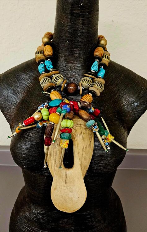 Isn't this Indonesian Ethnic Tribal Wood Scream Mask whimsical in a very artsy kind of way? This lightweight statement pendant-statement necklace features a 6.5" x 3.5" hand carved blonde wood mask with beaded ethnic hair made from various gemstones, corals, wood, rondelles, metal needle beads, rhinestone rondelles, and glass seed beads. The double strand necklace is comprised of wood barrel beads, bronze rhinestone rondelles, coconut disks and African lost wax cage work brass beads. The back is finished with faceted crystals and rhinestone rondelles. The inner strand adjusts from 19-24". Gold tone hardware and a lobster claw clasp closure. A OOAK Art to Wear piece from the Atelier of Kat Kouture. NOTE: This is a fairly lightweight piece. I can add more chain links if needed, free of charg Rocker Chic Accessories, Styled Jewelry, Scream Mask, Ethnic Hair, Runway Jewelry, Bold Statement Jewelry, Wood Mask, Ethnic Hairstyles, Blonde Wood