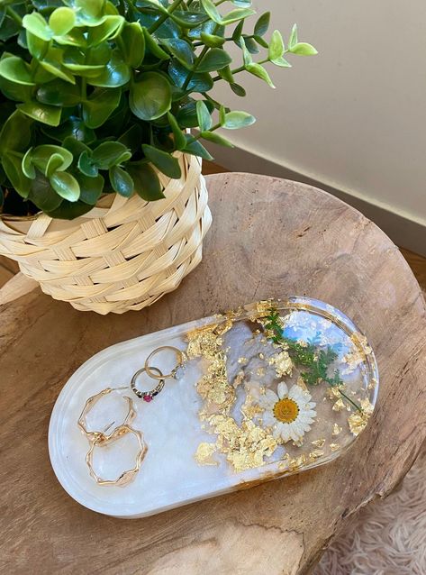 Tray tray made of crystal epoxy resin. This pretty cup can be used to put your jewelry, your keys, your perfumes, your make-up, your glasses, and will match in each room of your house ✨ If you are an artist or nail artist, you can use this decorative tray in flowers to affix your colors, varnishes or brushes. Each tray is encrusted with a dried daisy, plants and gold leaf. The pearly white dye used is natural. Each piece is unique, handmade with 💜 in our workshop in France. 📲 Do not hesitate t Cup Tray, Resin Pour, Pretty Cups, Diy Resin Art, Jewelry Tray, White Jewelry, Trinket Tray, Flower Lover, Resin Diy